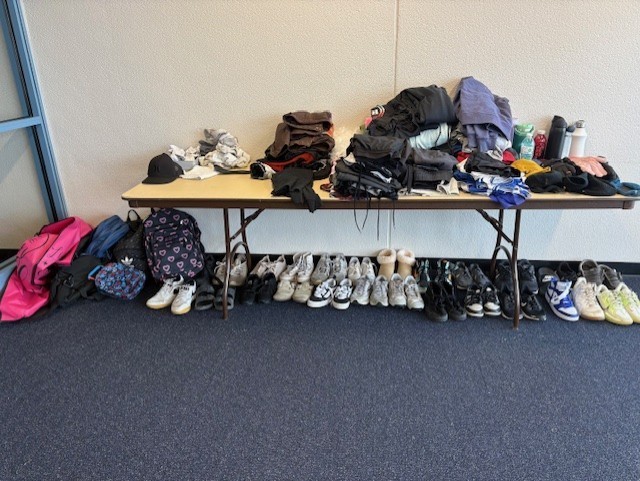 Lost and found table with clothes and lots of shoes