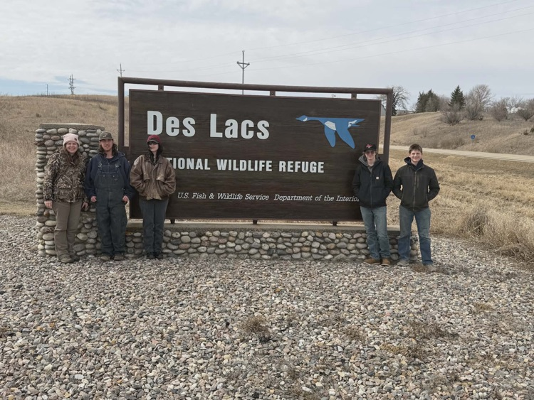 kids in front of a refuge sign at Des lacs 