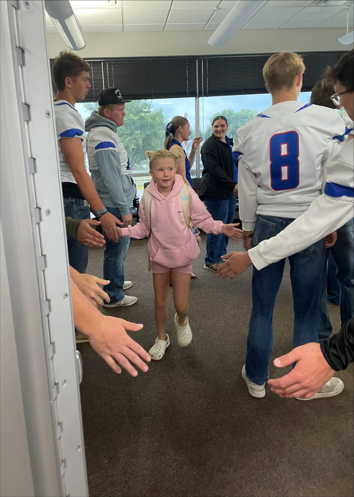 football players greeting students