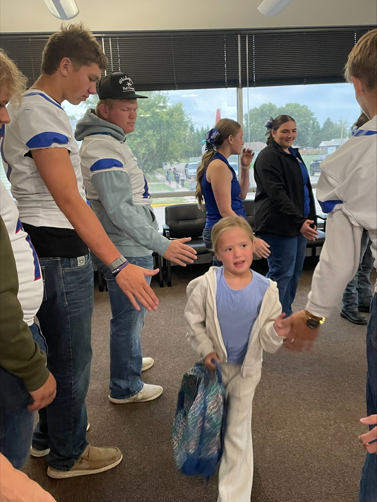 football players high fiving students
