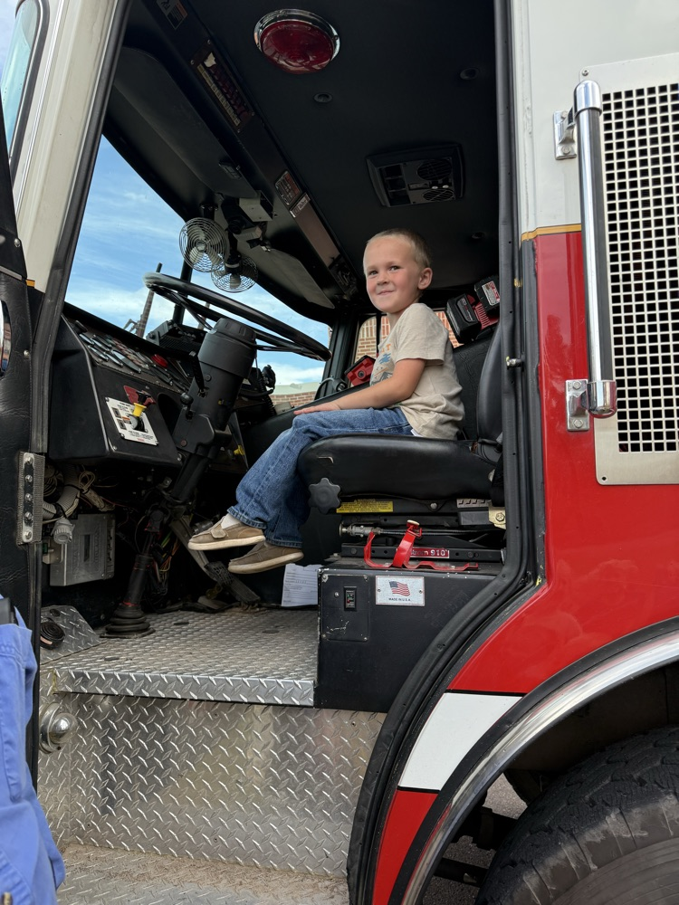 Student sitting in fire truck.