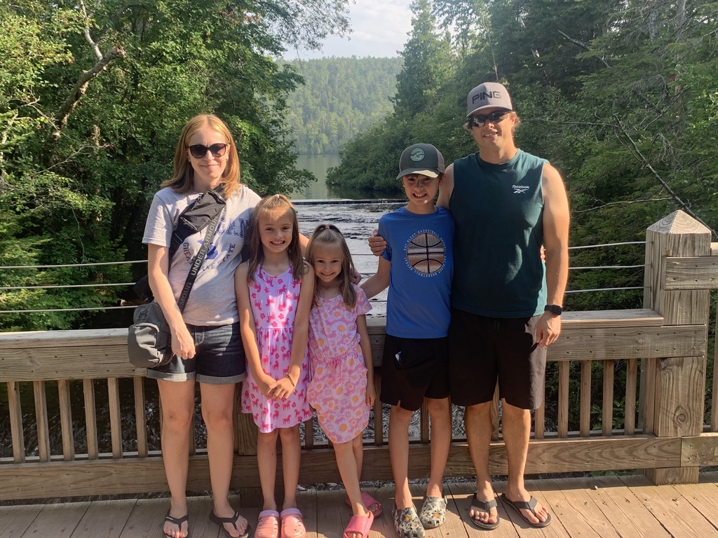 Picture of Mrs. Toutant and her family on a bridge overlooking a river.
