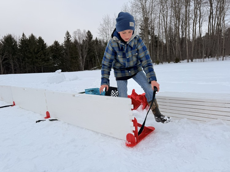 5th grader sets the wall pieces to our rink.
