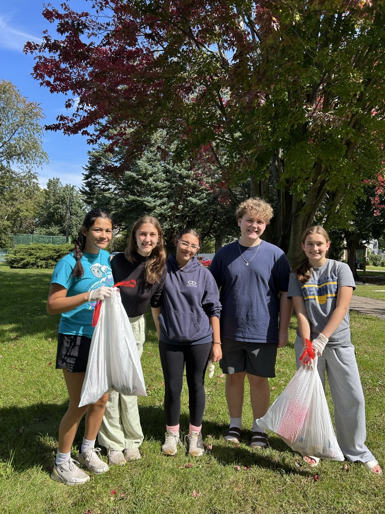 5 Sterling key club members holding trash bags from the park cleanup