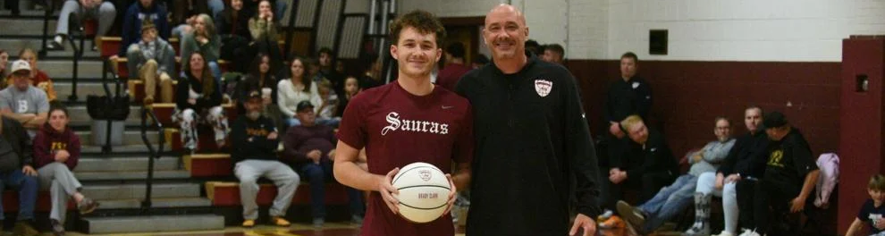 South Stokes coach Jason Clark presented Brady Clark, his son, with a basketball commemorating his 1,000th career point against Rockingham County.