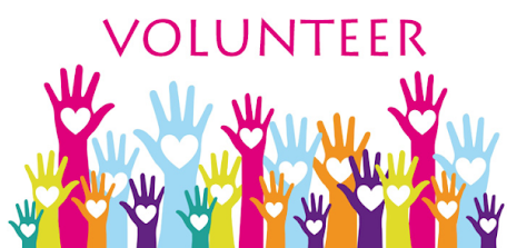 A colorful graphic featuring the word "VOLUNTEER" in pink capital letters at the top. Below the text, several rows of raised hands in various bright colors—including pink, light blue, purple, yellow, and teal—are displayed. Each palm features a small white heart in the center.