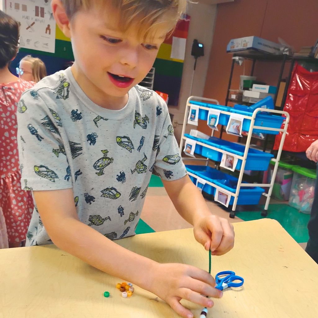 Students collaborate on engineering-inspired projects using everyday materials. The room is full of motion, invention, and bright colors, capturing the spirit of exploration.