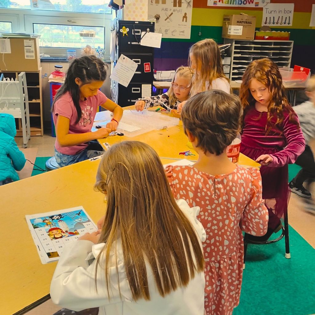 Students collaborate on engineering-inspired projects using everyday materials. The room is full of motion, invention, and bright colors, capturing the spirit of exploration.