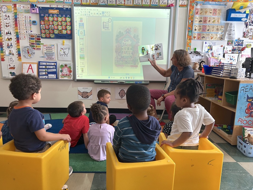 Mrs. Williams, the administrative assistant at the Jones, is pictured here reading the book "Our School is a Family" to Ms. Smith's preschool class.