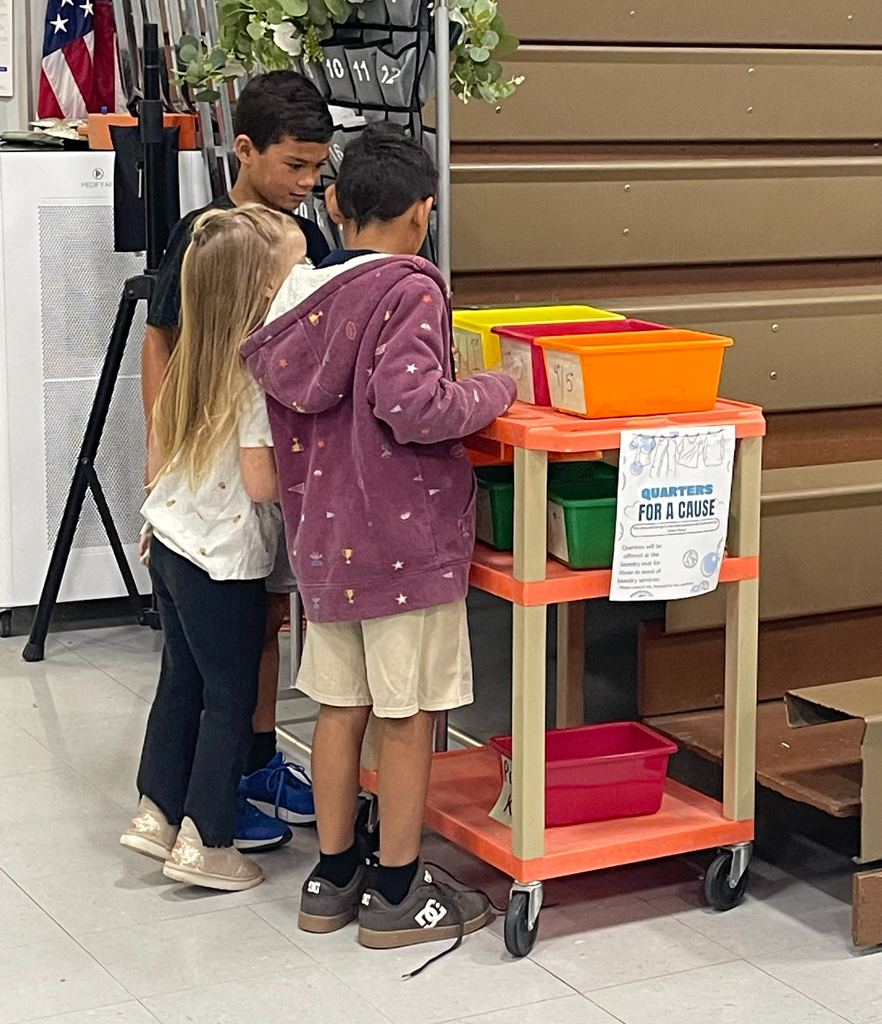 students putting quarters into their classes bucket