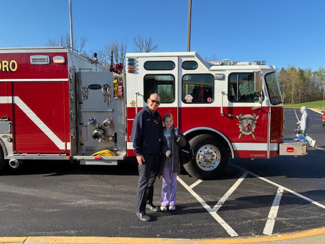 Scarlett Chalkwater and streetsboro firefighter Brian  Novotny stand in front of fire truck
