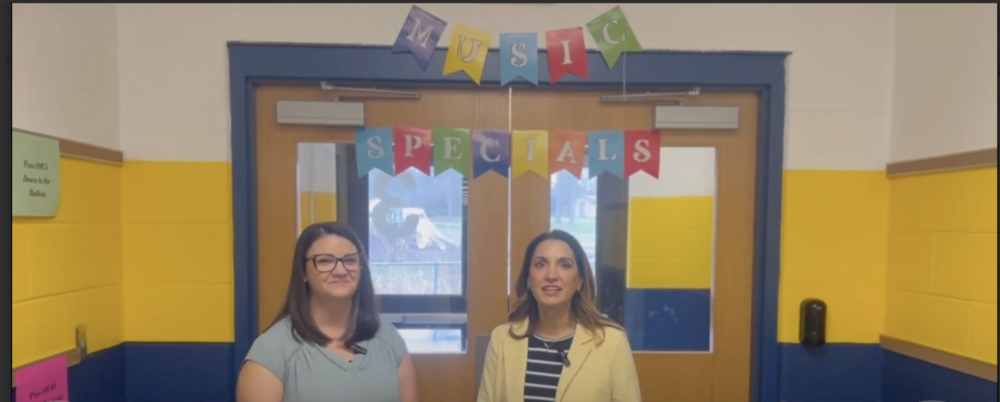 Michelle Kravets and Cindy Deevers stand in HDI in front of double doors. 