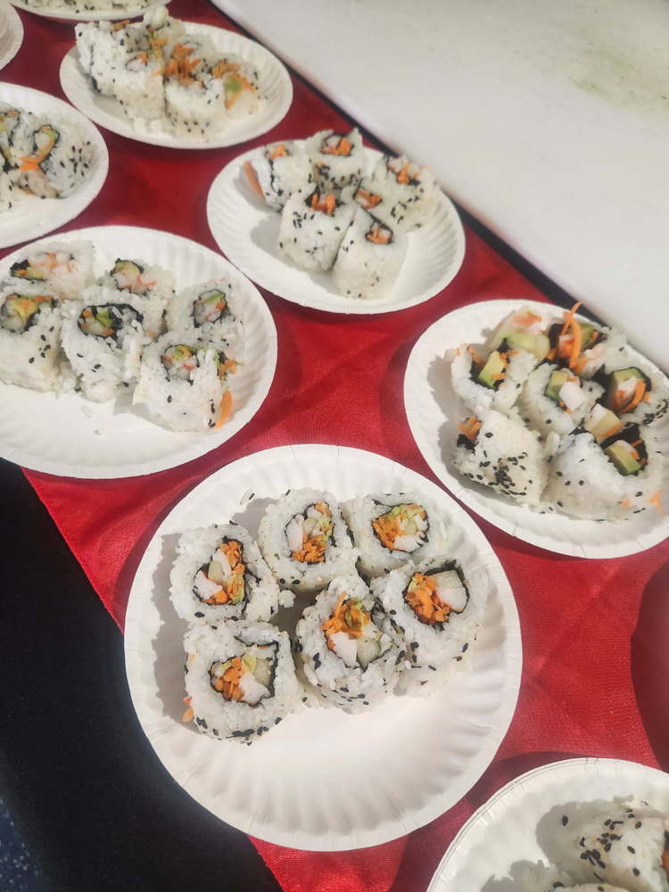 Plates of sushi rolls on a red table runner