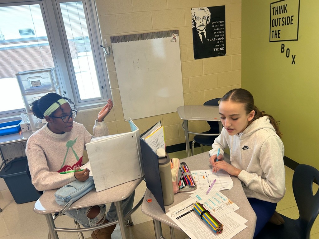 Students sitting at desk with dividers playing math games