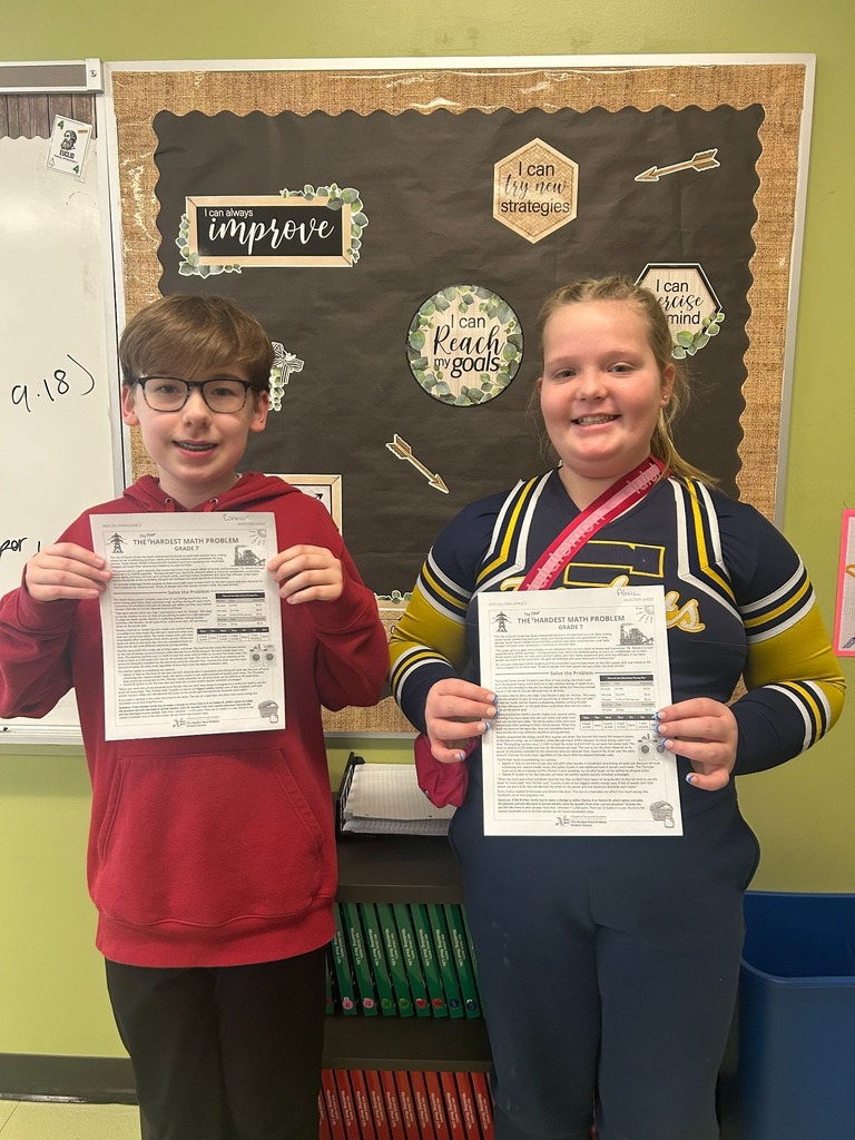 Two seventh grade students displaying certificates for completing "The Hardest Math Problem."