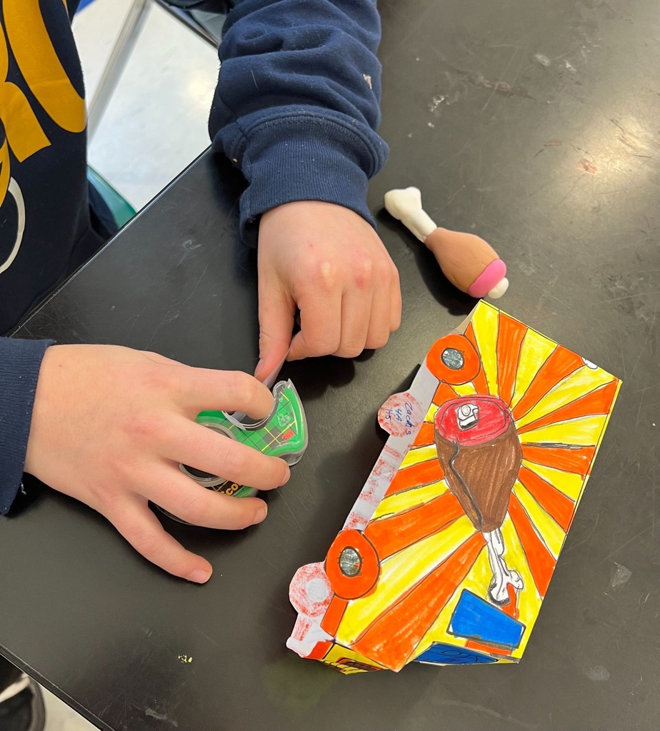 Student using tape to construct their finished food truck prototype!