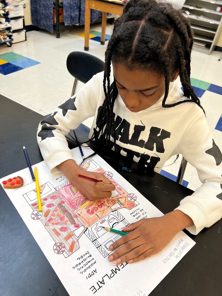Students drawing on papers with colored pencils to bring their food trucks to life!