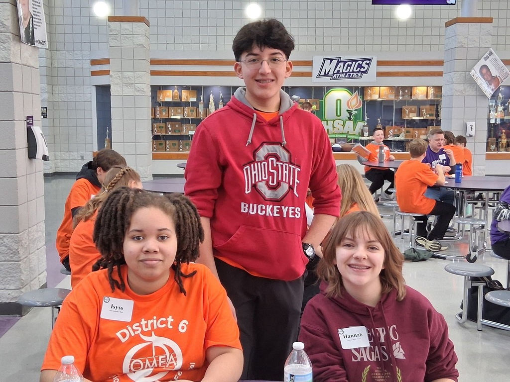 Isyss, Hannah, and Anakin in a cafeteria with name tags on.