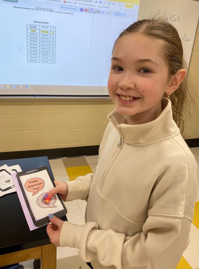 Student holding up their paper valentine.