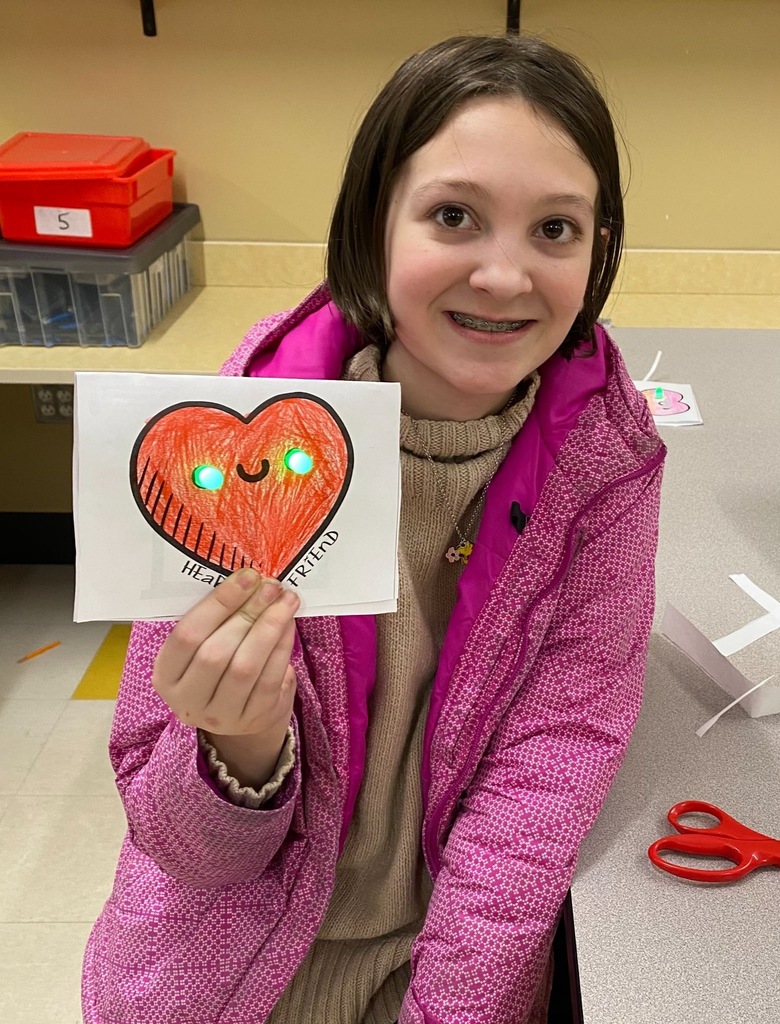 Student holding up their paper valentine.