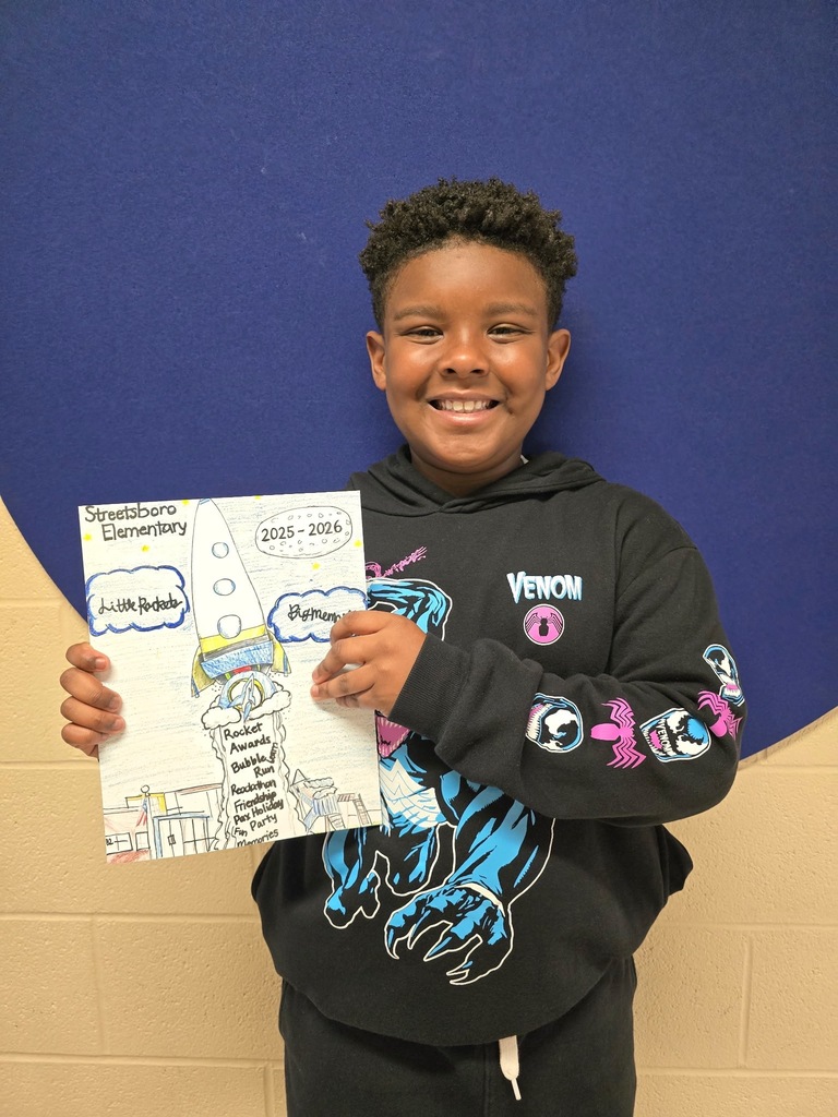 Adian holding his yearbook design