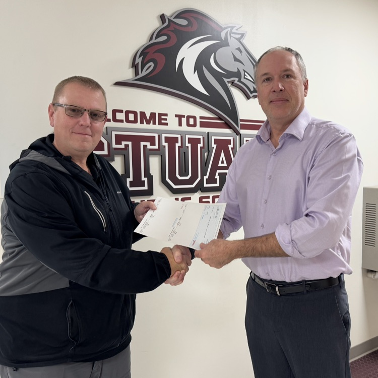 Mahaska Bottling presents a check to the school.