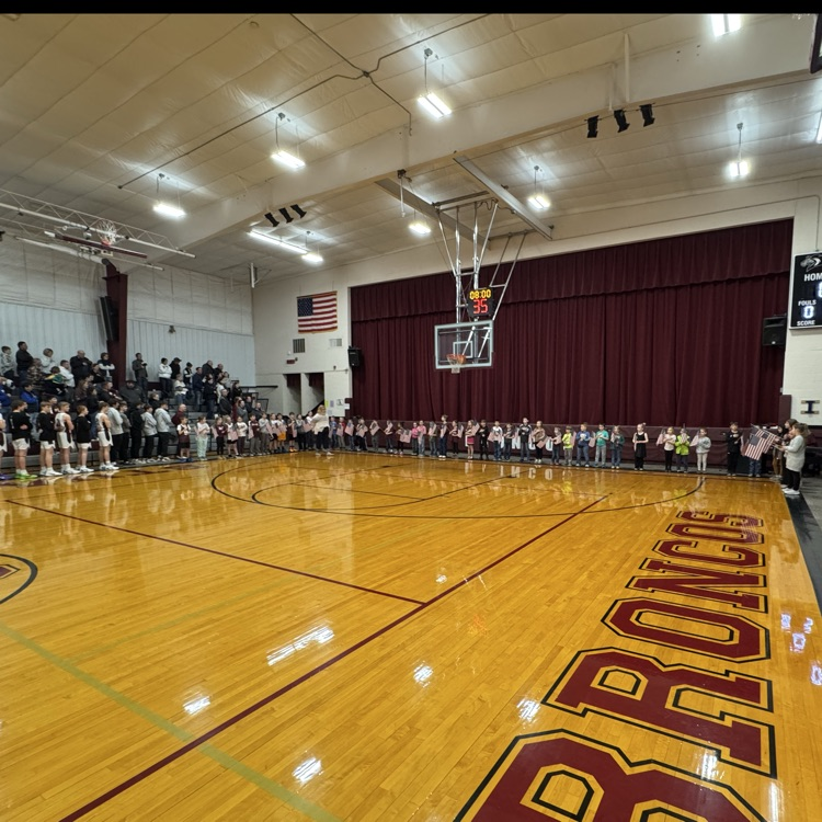 K-4 sing the national anthem.
