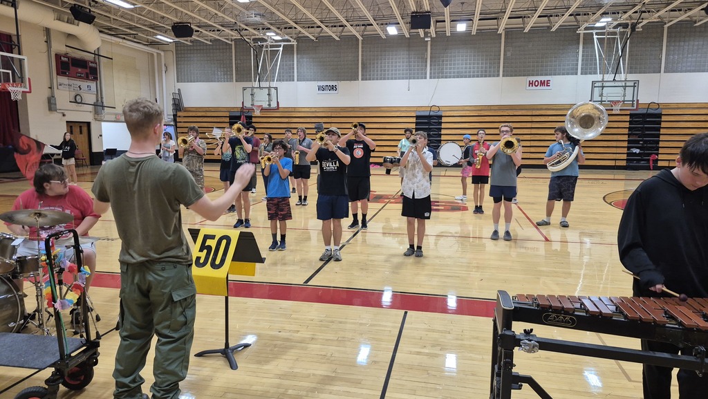 Members of the Sullivan High School Band perform their halftime routine indoors during stormy weather.