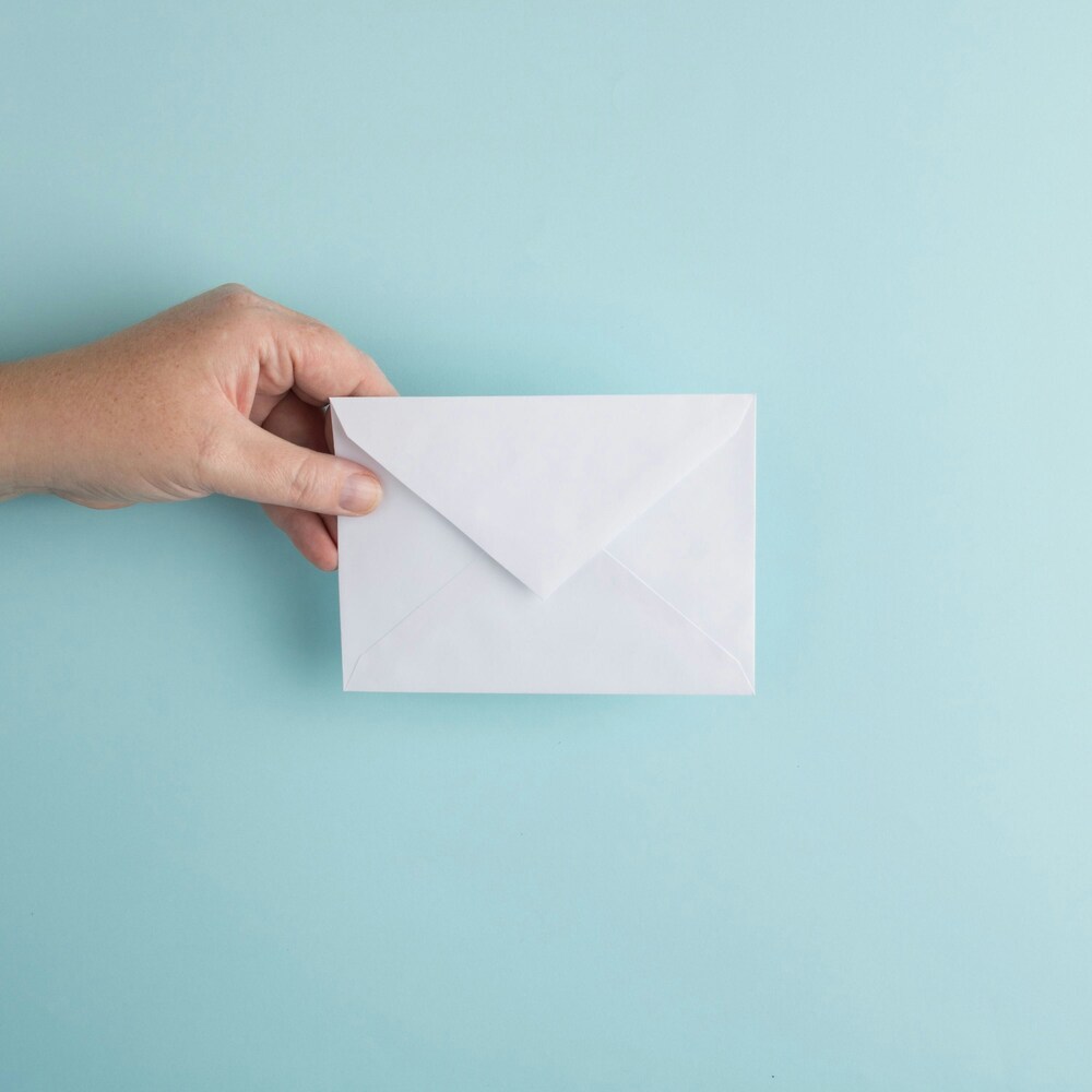 blue background with hand coming in the picutre holding a white envelope that is not open