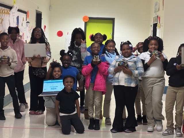 Ms. J. Jones 3rd and 4th grade STEM students with device.
