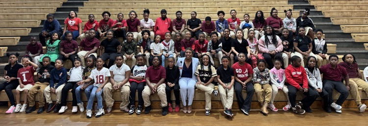 Superintendent with 2nd-4th grade YWE students in the gym after reading to them