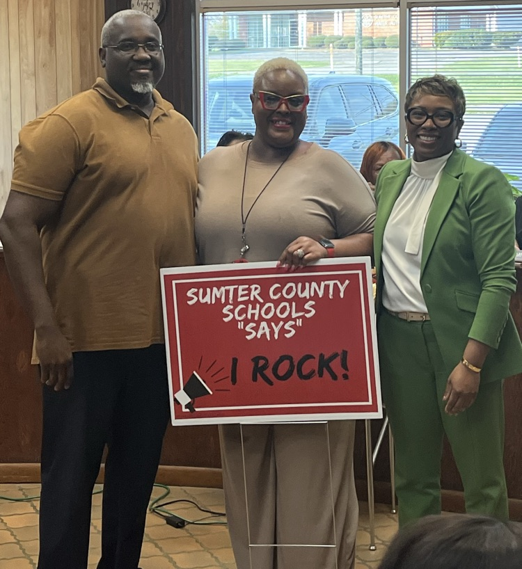 Marcus West, principal of SCHS and Superintendent Dr. Marcy Burroughs are recognizing Michelle Merriweather for perfect attendance Tuesday night’s board meeting.  The teacher is holding a sigh that says Sumter County Schools say “I Rock"