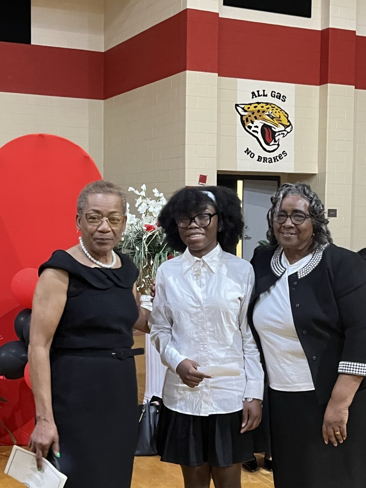 Two sponsors presenting a student with a $25 gift card for being the first student to show up to the program