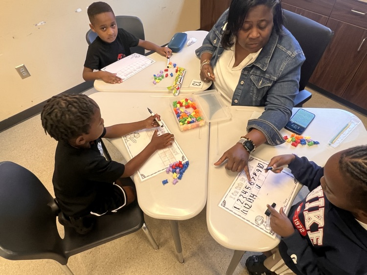 students at desk with teacher in small group
