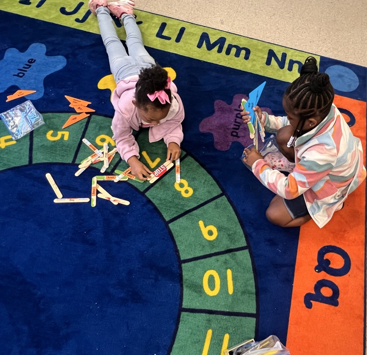 students on a rug building an object