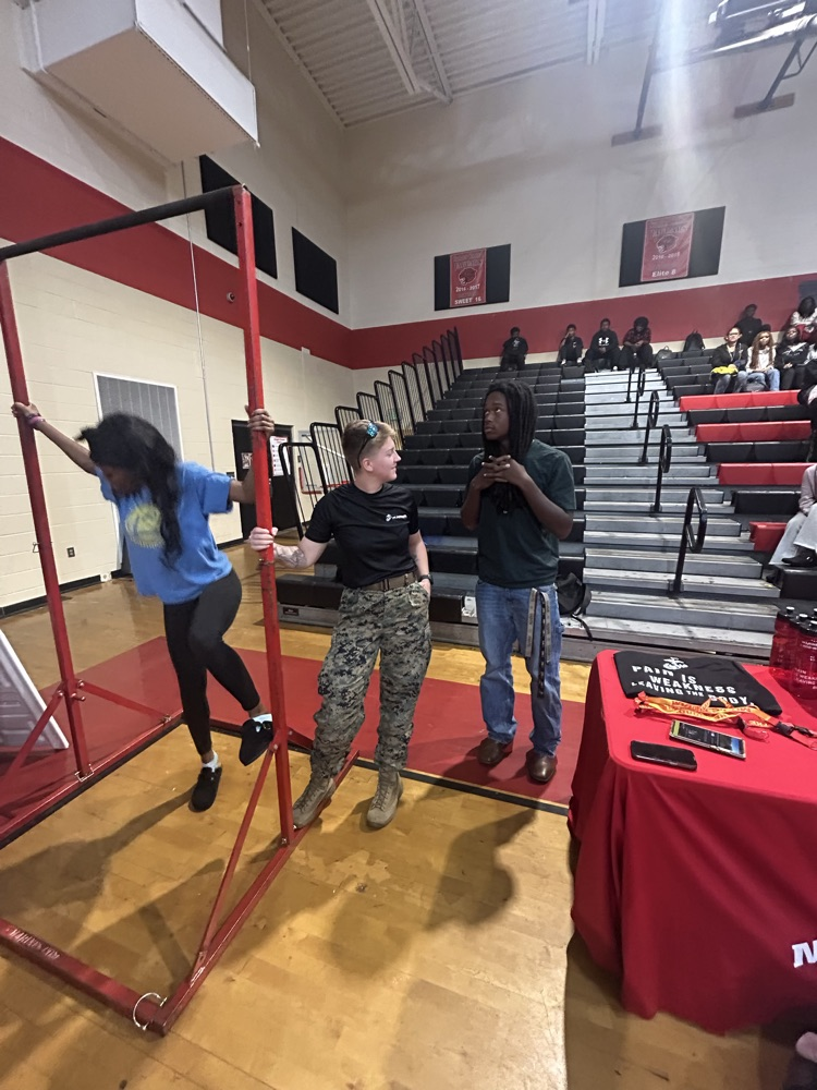 Student about to do pull-ups and another student talking with military recruiter