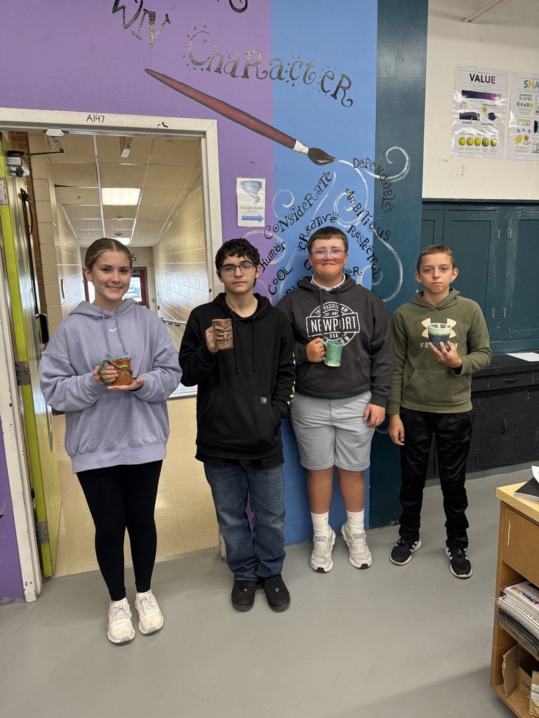Students from High School Art showing off their finished Ceramic Mugs
