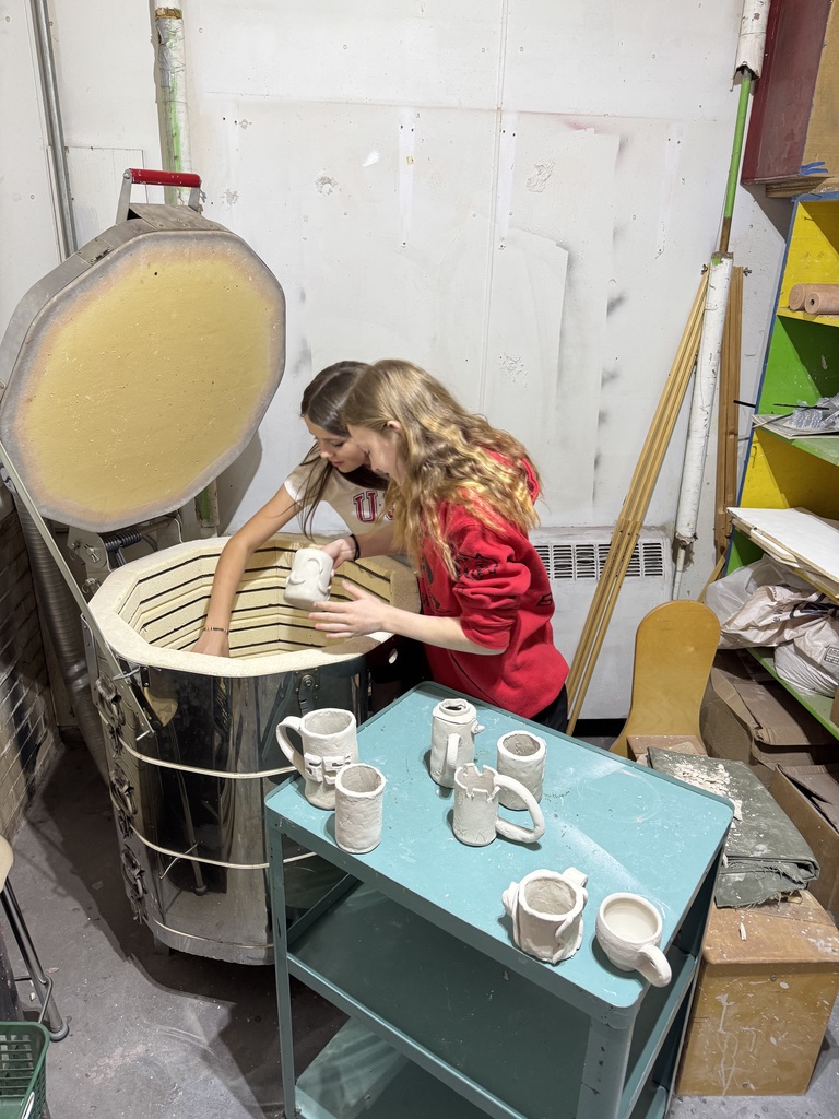 6th Graders helping load the kiln