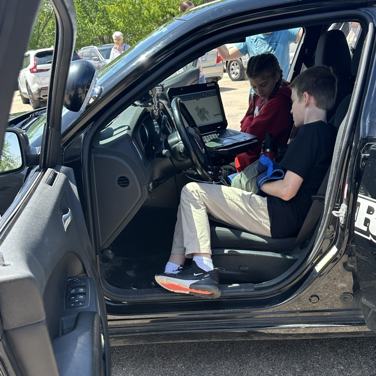 A student checking out the front of a police car