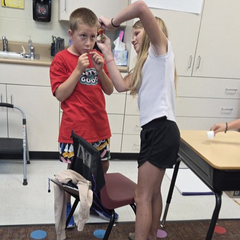 student lifting a worm up to try and save him!