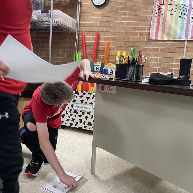 Students decoding a hidden picture under a desk.