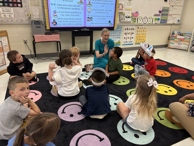 students in the floor with Ms. Coe