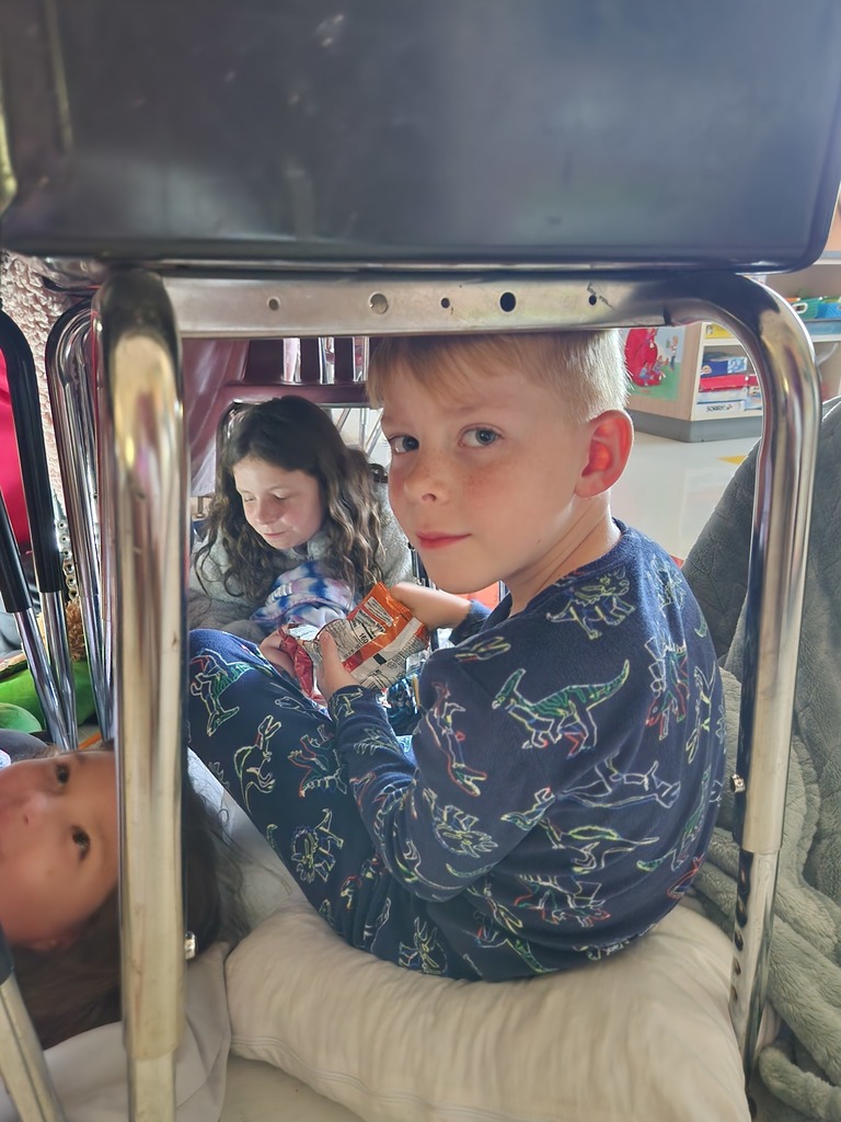student reading under their desk by flashlight