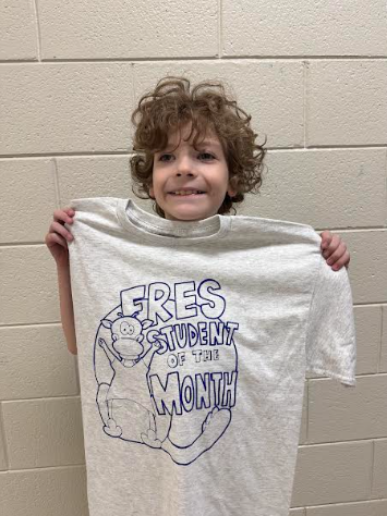 Student receiving his student of the month shirt