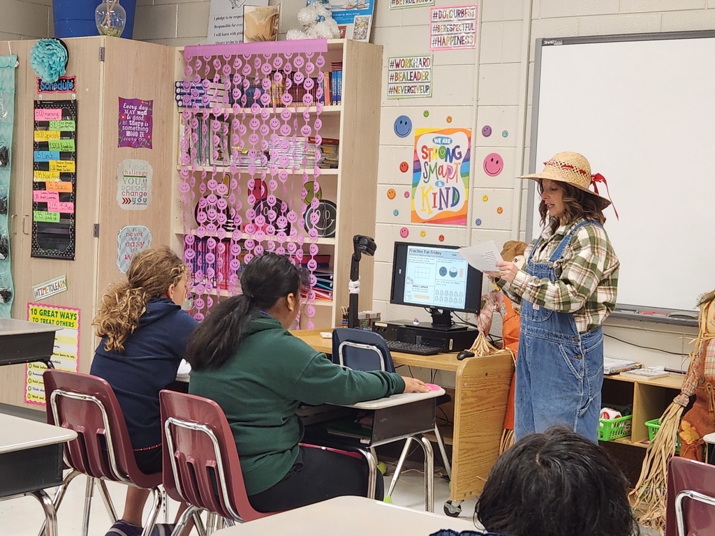 Mrs. Edwards dressed as a farmer reading poetry to third grade