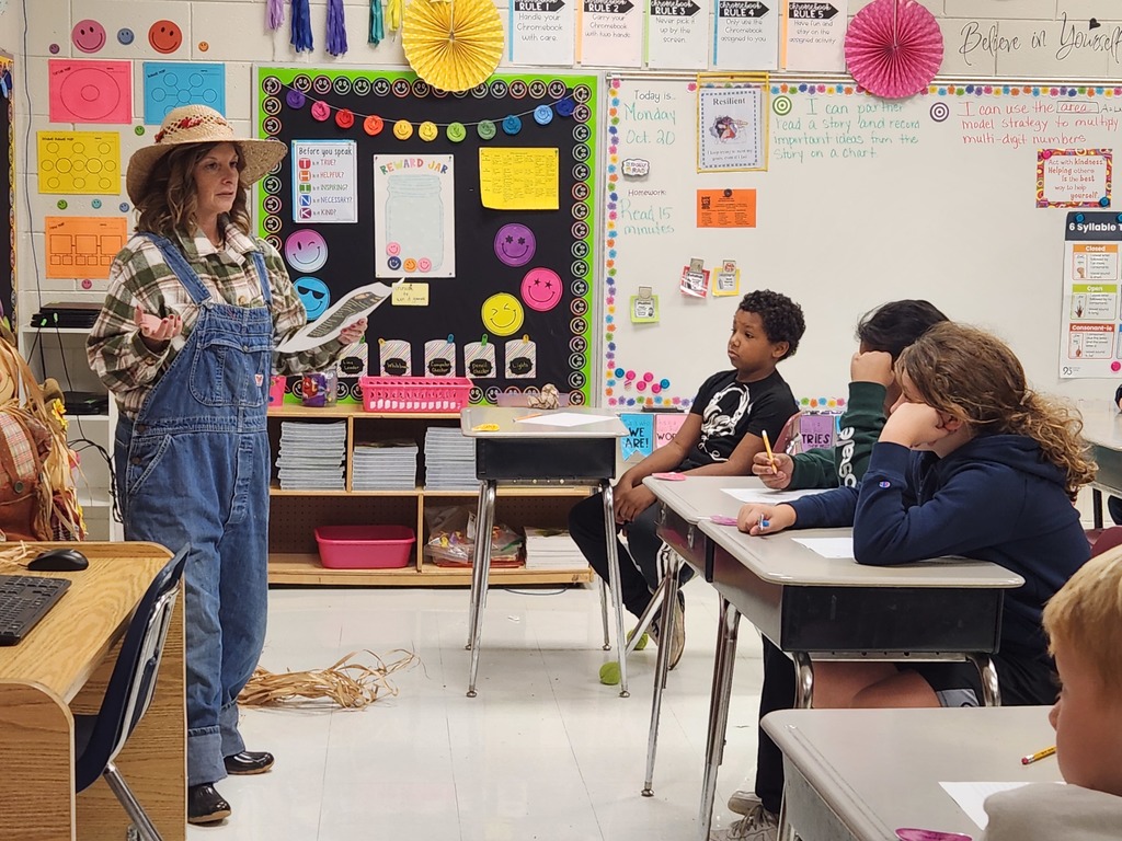 Mrs. Edwards dressed as a farmer reading poetry to third grade