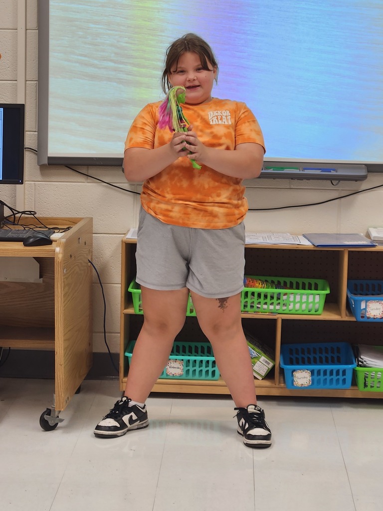 student showing the item they brought to class