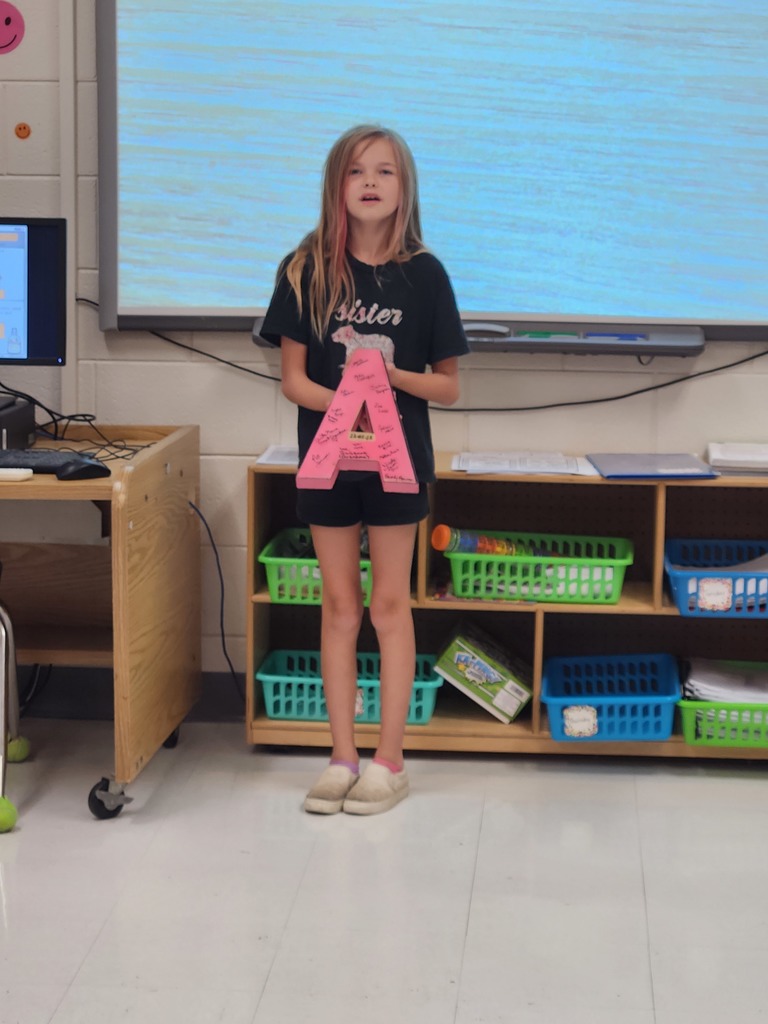 student showing the item they brought to class