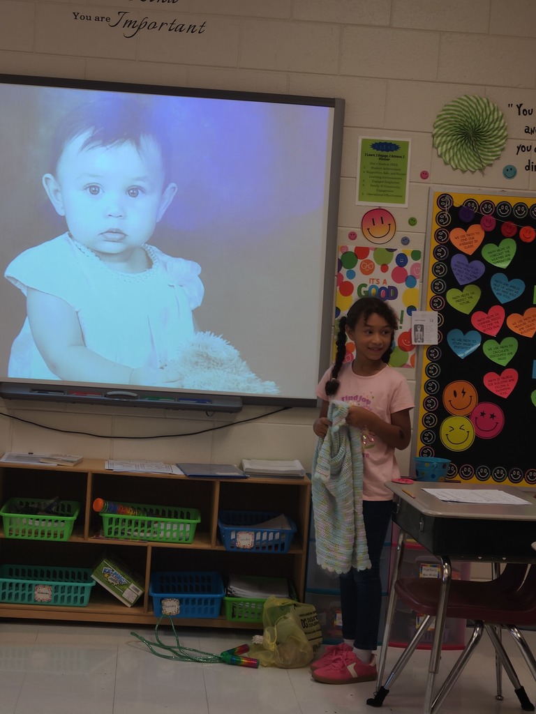 student showing the item they brought to class