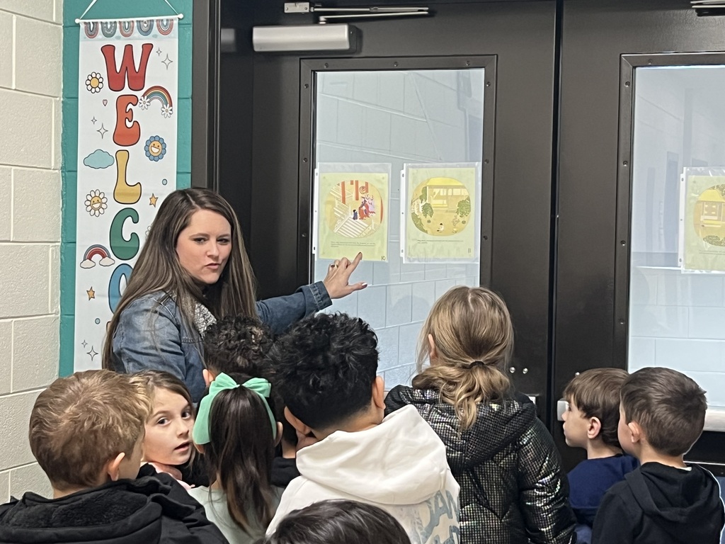 students reading during a story walk through the halls
